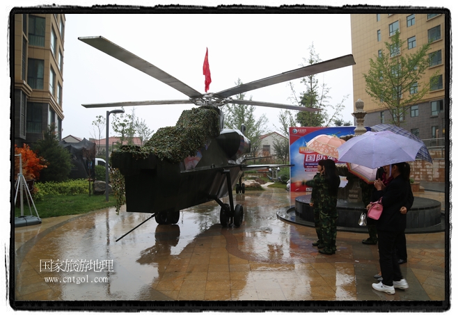 小區(qū)突然出現(xiàn)“飛機(jī)坦克”，其中殲15艦載戰(zhàn)斗機(jī)一架、99式主戰(zhàn)坦克一輛、武直-10武裝直升機(jī)一架，吸引了眾多市民雨中圍觀、合影。